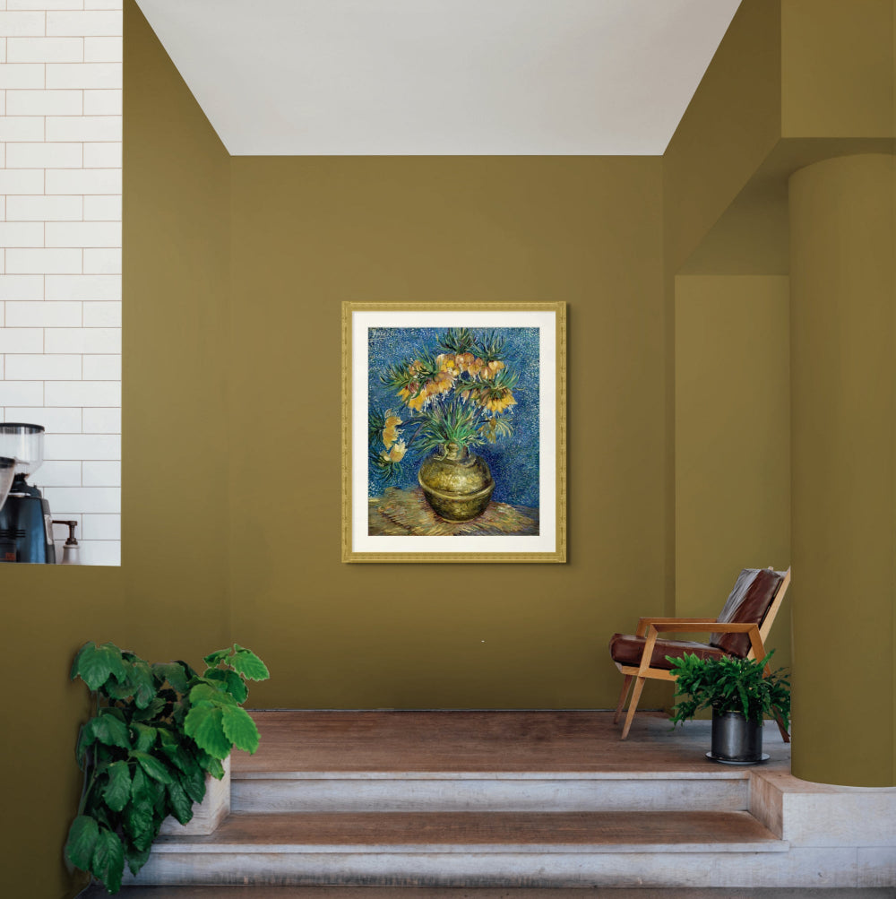 A cozy corner with mustard walls and plants showcasing a still art print of flowers by Vincent van Gogh